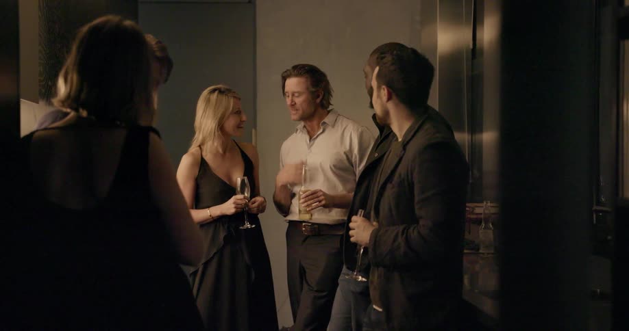 Group of people standing and talking inside while drinking beer and champagne