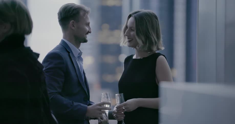 A man and woman converse at a party