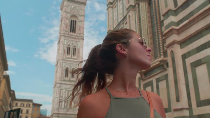 Woman wears sunglasses as she looks at buildings