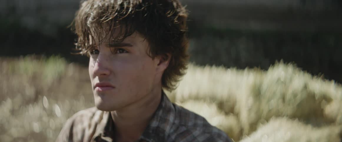 A young man sweats while unloading hay