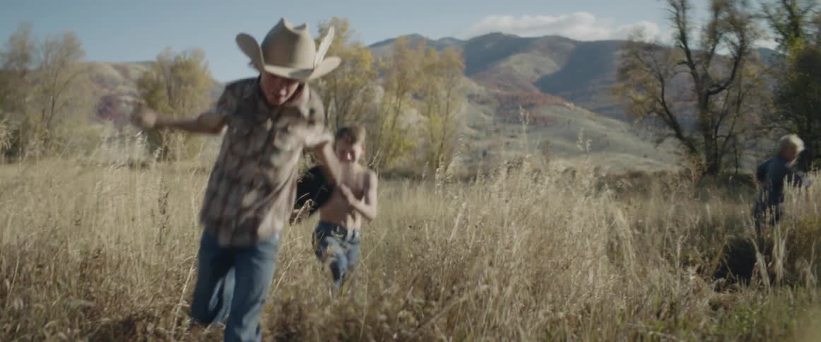 Children run playfully through a field