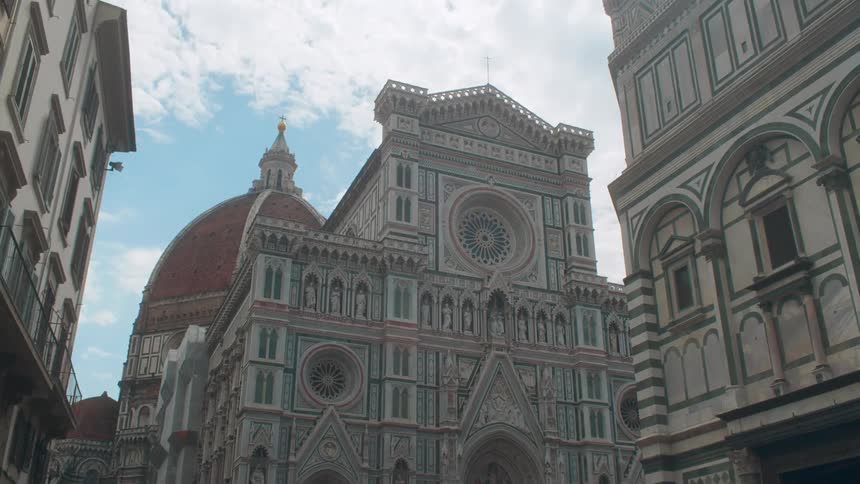 The tall building is made of stone with many domes