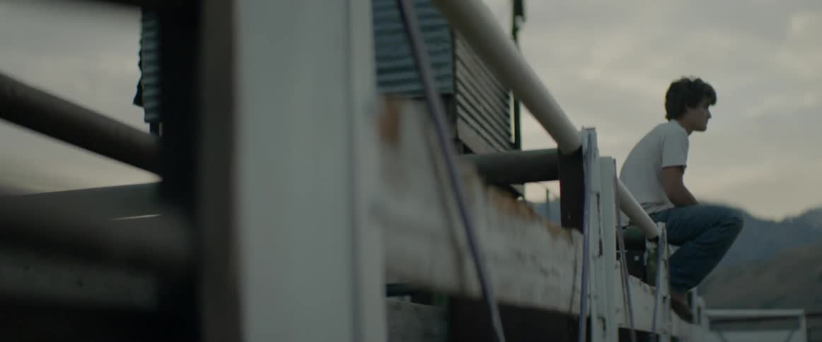 Man sits on the side of a fishing pier
