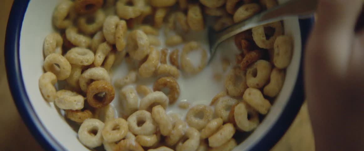 A person eats cheerios from a bowl