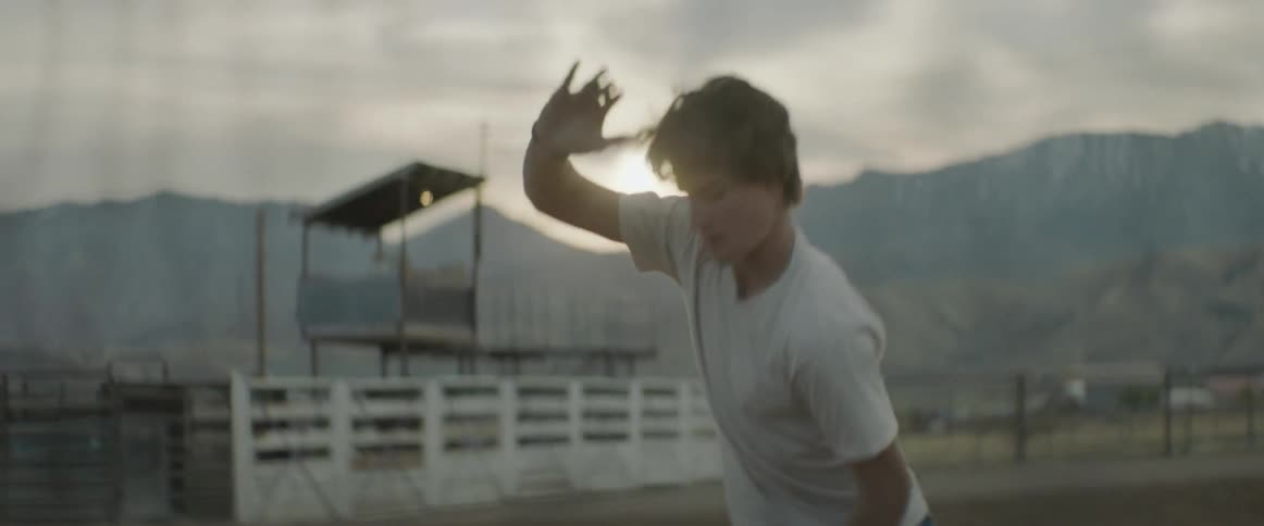 A man is dancing inside of the empty rodeo ring