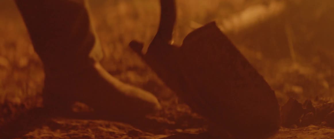 The dirt is being dug and thrown forward towards the flames