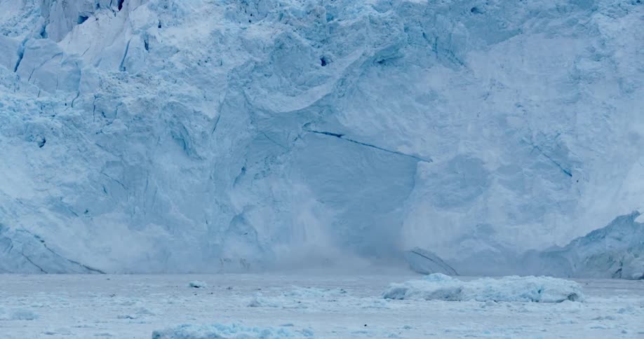 A large ice wall is white with frozen water all around