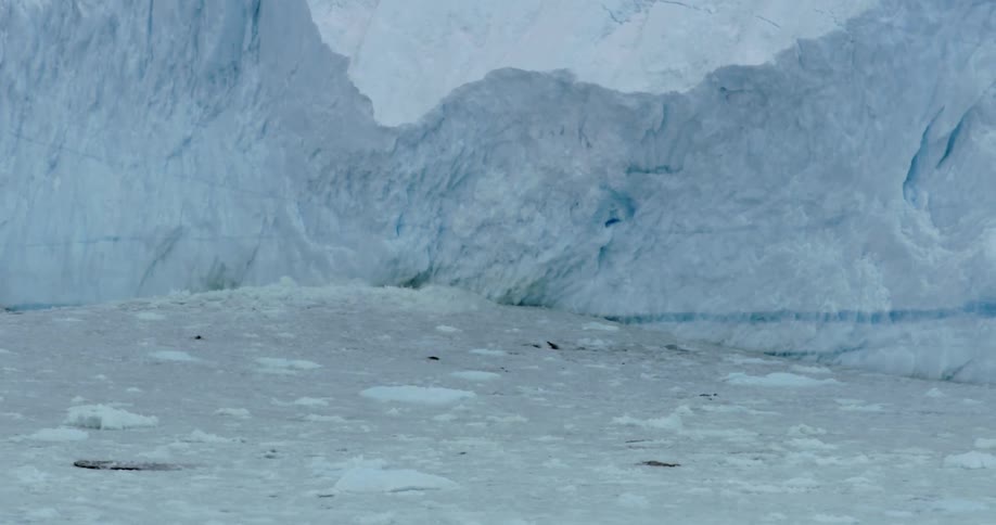 Waves of ice are crashing against a large ice