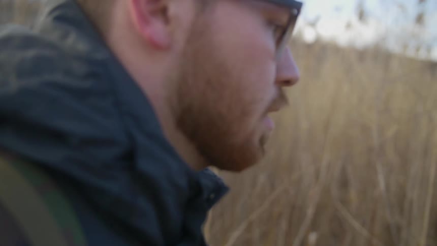 Man walks in a field on a cloudy day