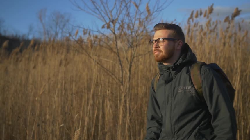 A man walks through tall grass