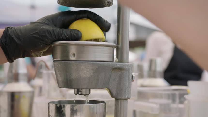 Person using machine to squeeze and juice a lemon