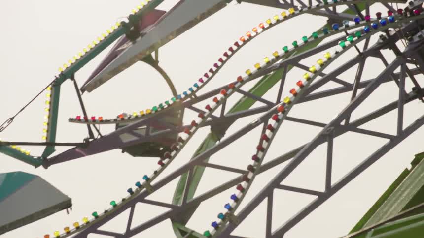 A tilt-a-whirl rotates at a county fair