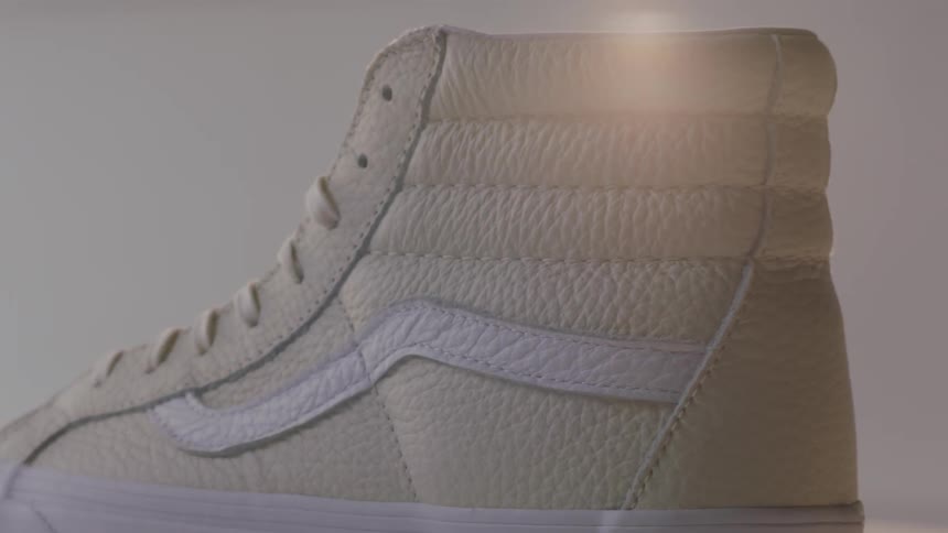 A white sneaker rotates under a light