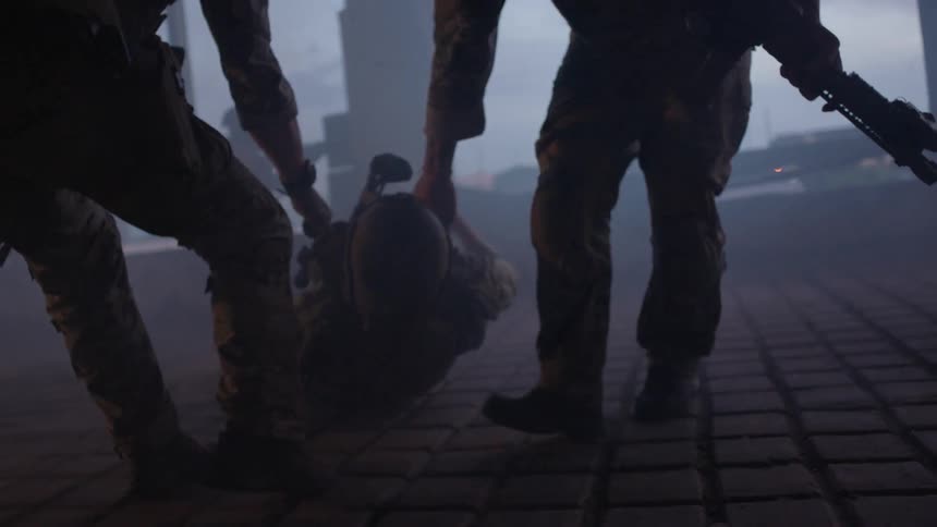 Soldiers drag a fallen comrade
