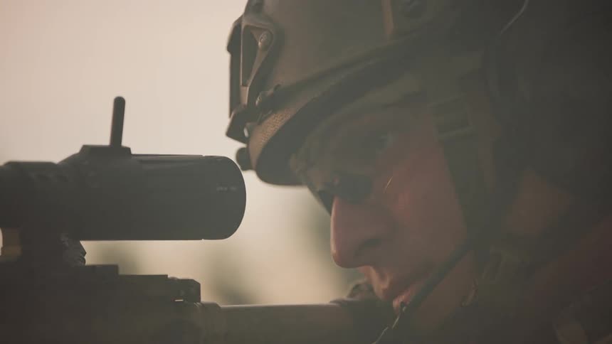 Soldier peers down the sight of his rifle
