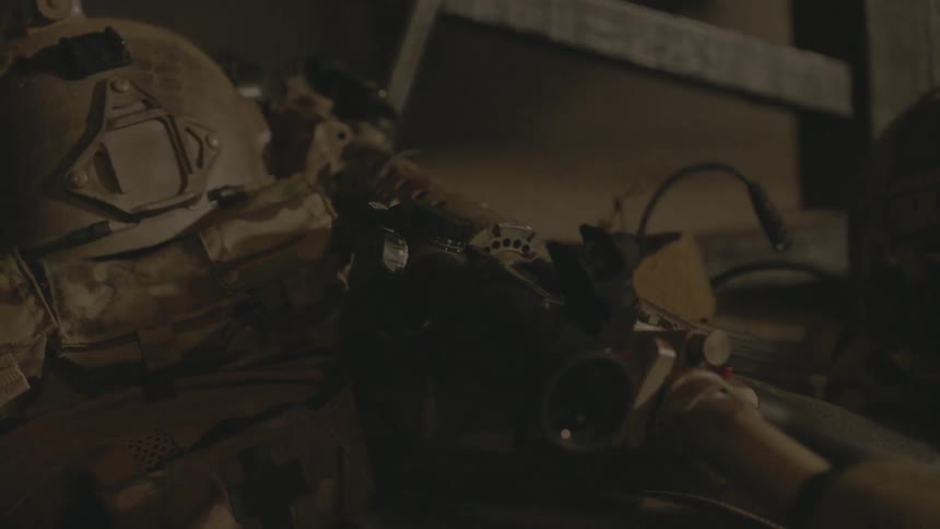 A gun sits next to a folded up soldier's uniform