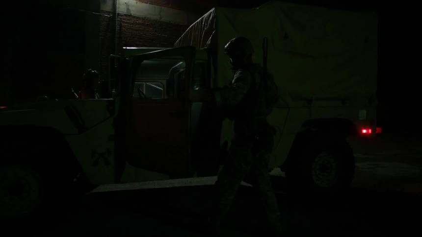 Soldiers entering a military vehicle at night