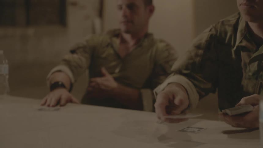 Soldiers in uniform play cards