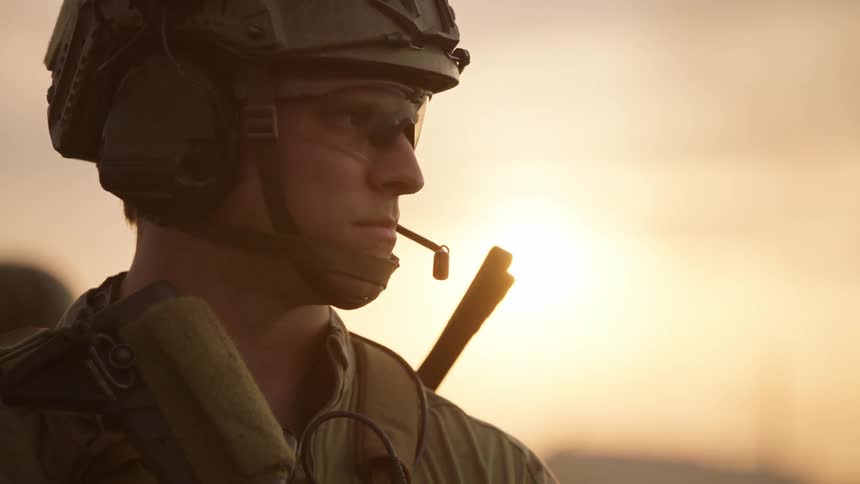 Soldiers stand guard outside at sunset