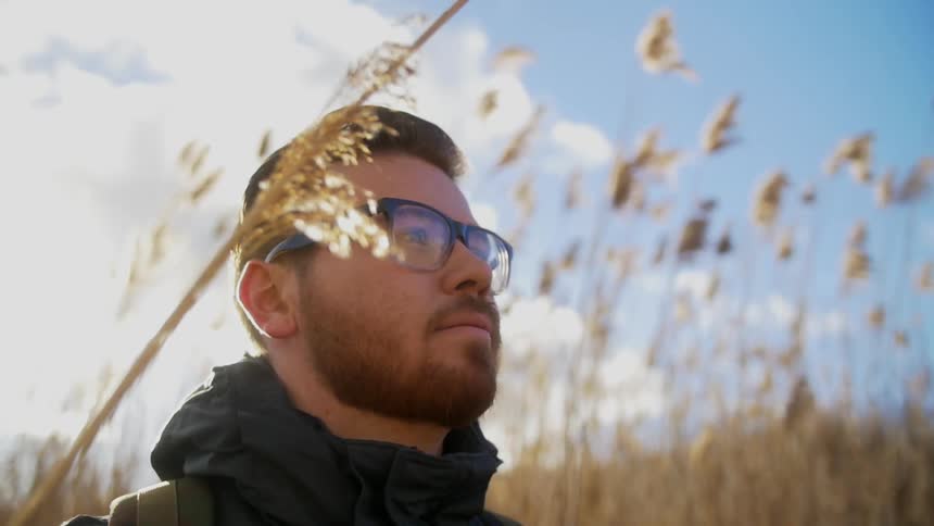 A man stands in a field with tall grass