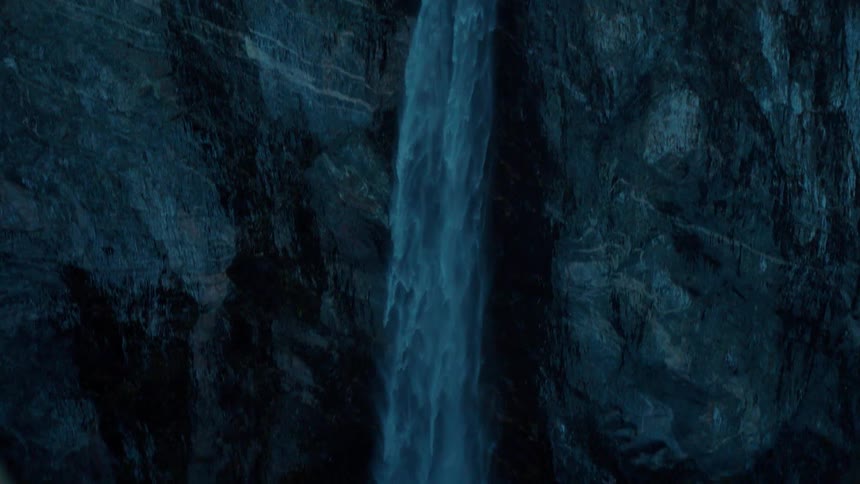 The waterfall pours down into the valley below