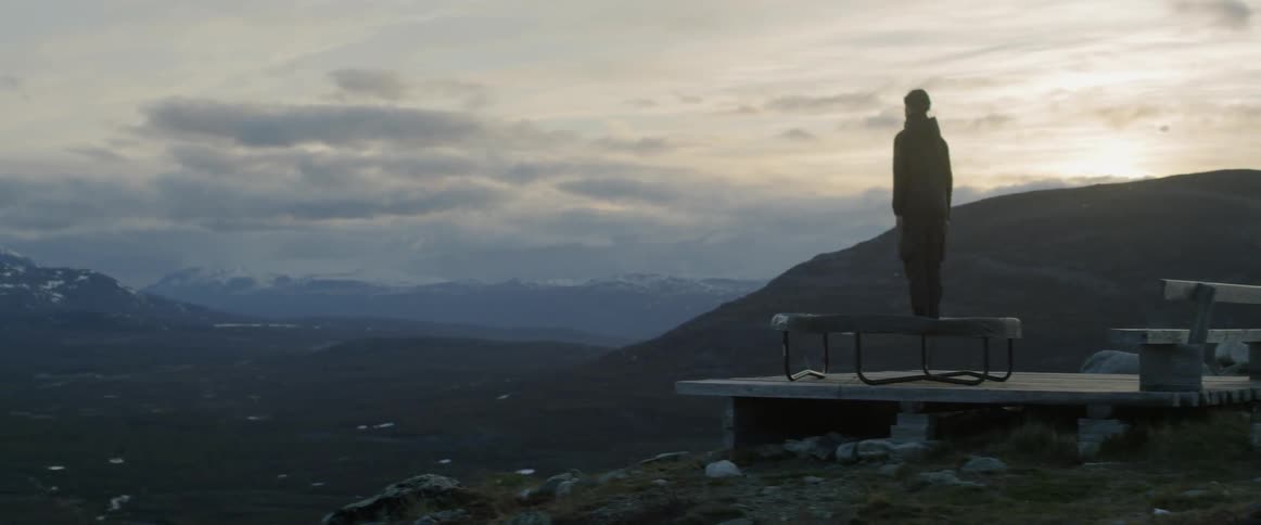 A man jumps on a trampoline atop a mountain