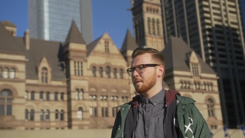 Man standing in a city turns around