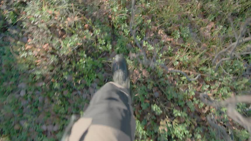 Man walks through forested area in boots