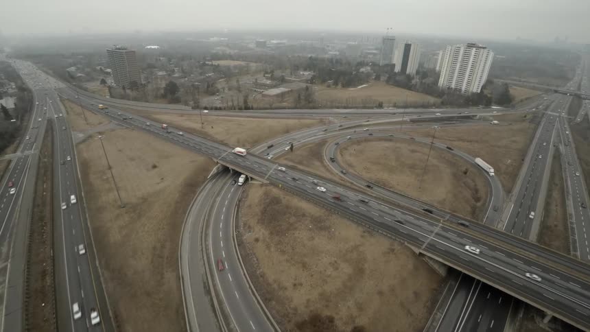 A busy highway interchange with tall buildings in the distance