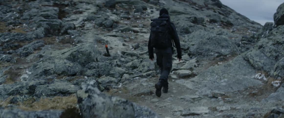 A hiker climbs up a stone mountain