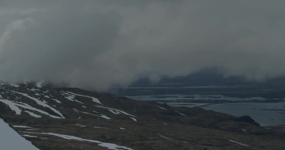 Clouds pass above and through the mountain