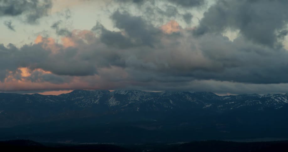 The clouds move over the snow covered mountain