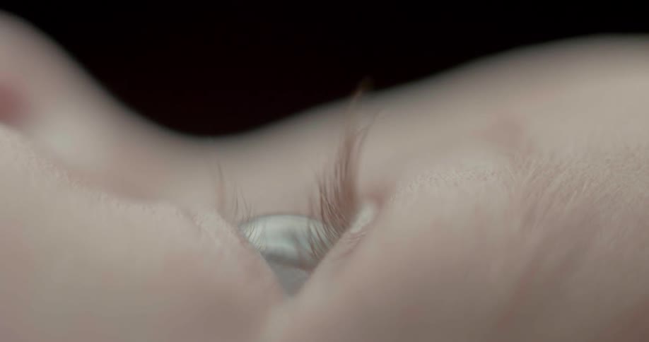 A baby blinks its blue eyes