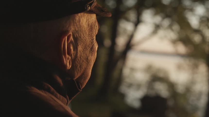 A man stands and looks towards sunset