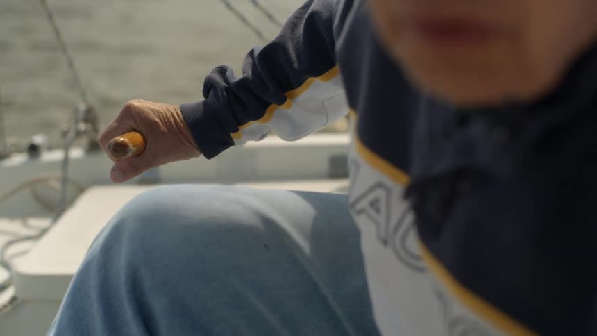 Man leans over while steering a boat