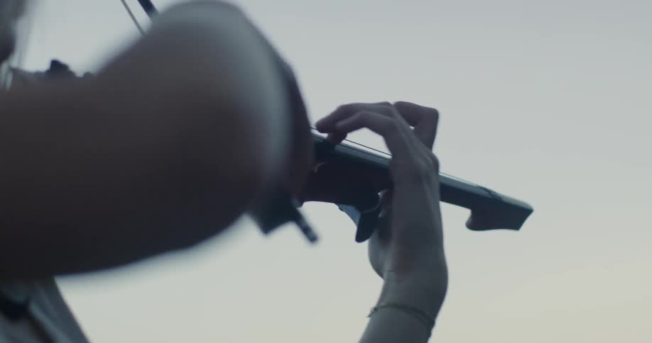A person is playing the violin on a cloudy day