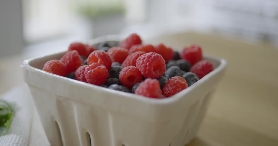 The container is full of berries on the table