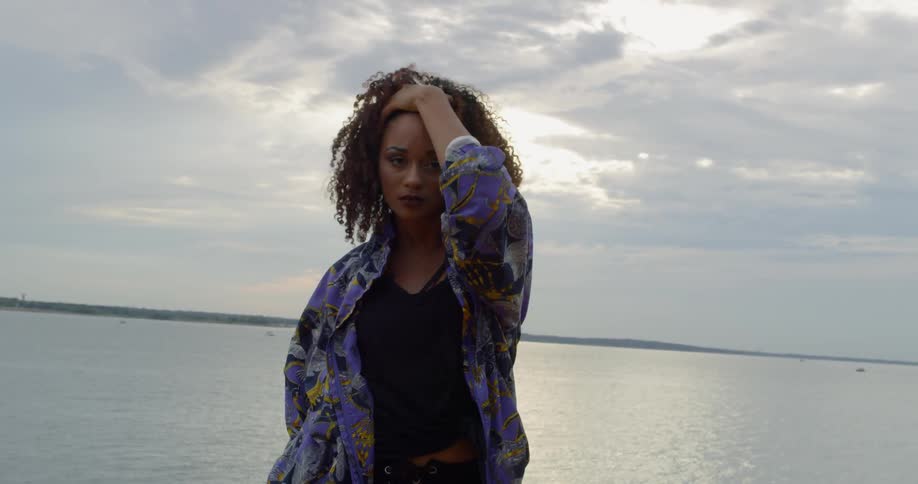Woman dances outside next to a lake
