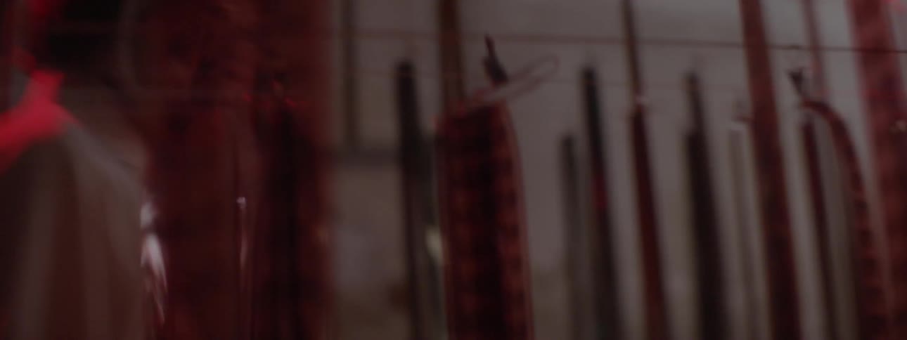 A woman walks past hanging rolls of film in a dark room