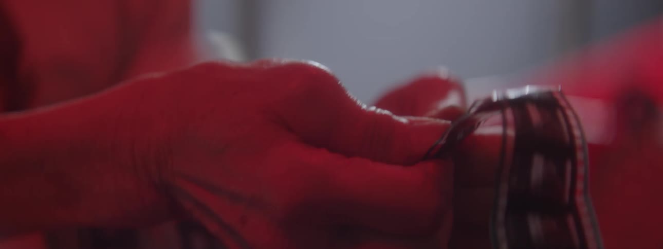 A woman twists and presses on a roll of film