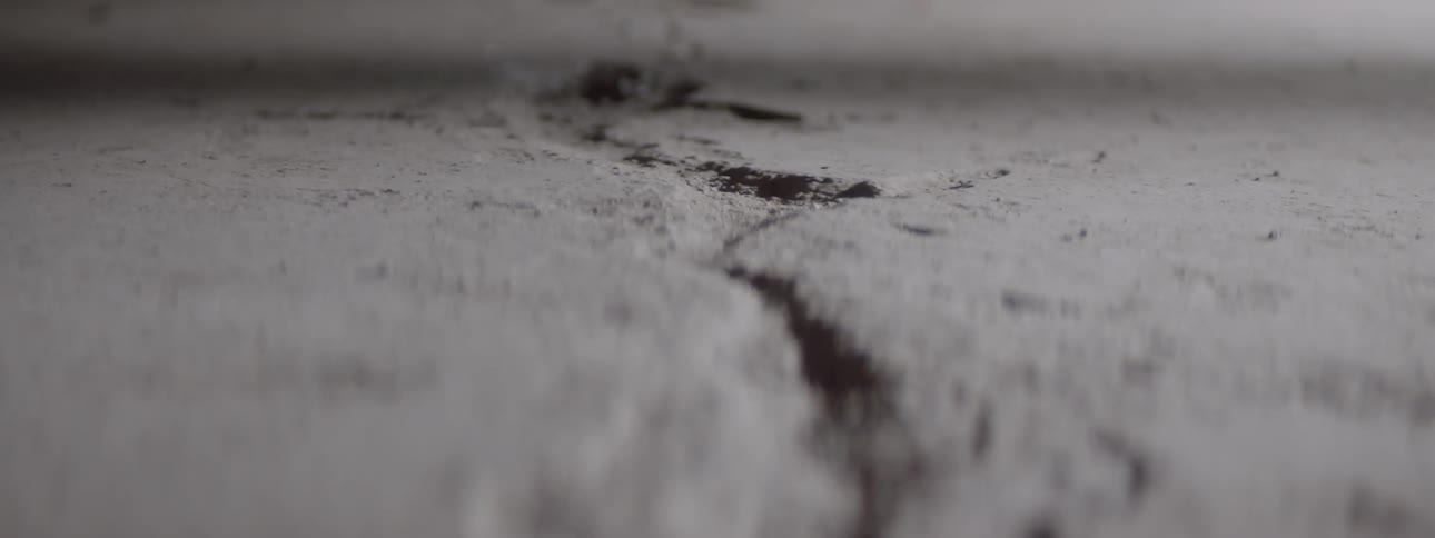 A crack stretches across a slab of concrete