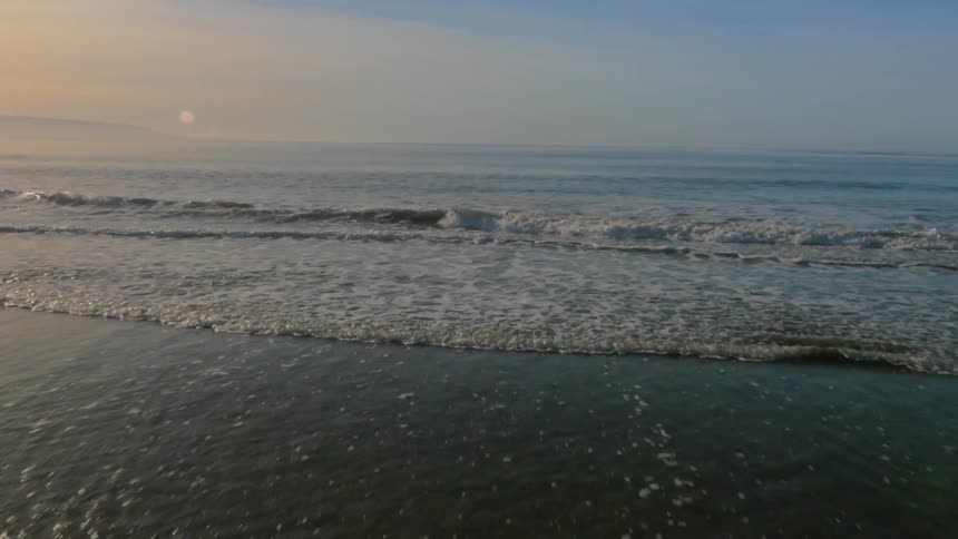 Waves flow onto the beach shore