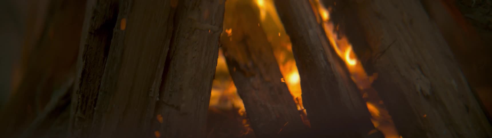 The campfire is burning the logs at night