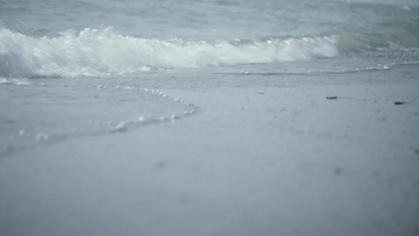 The waves slowly move over the sand