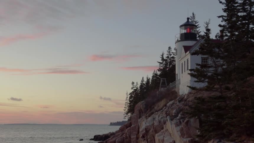 A Lighthouse Shines Brightly At Dawn