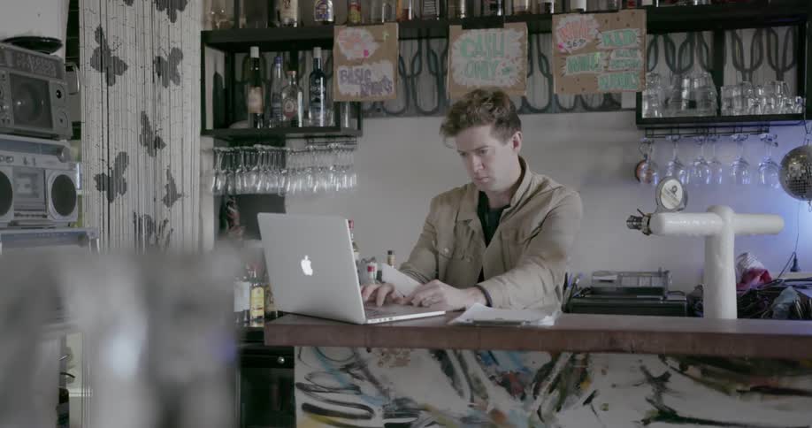 A man turns around to look at his laptop