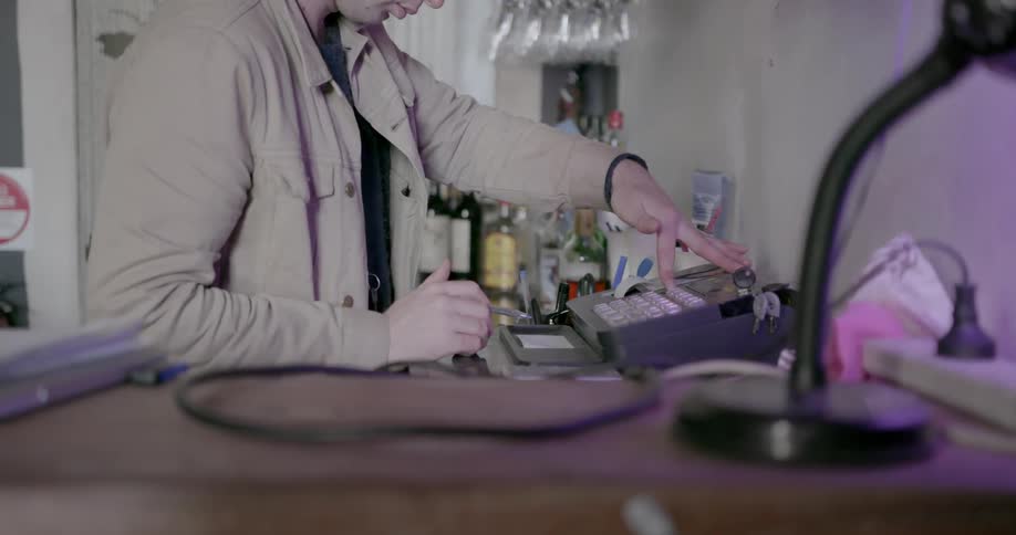 A man operates a register in a store