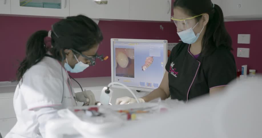 A dentist is working on someone's teeth