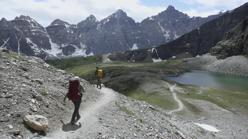 Hikers walk near a mountain lake