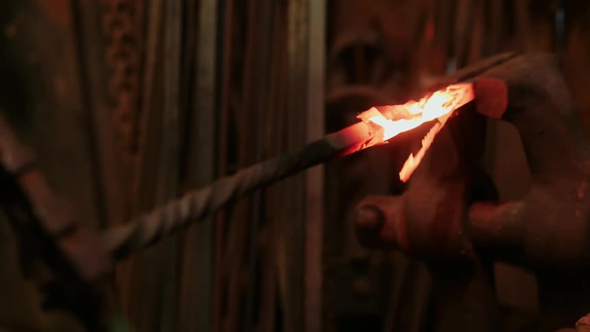 A blacksmith twits a piece of hot metal